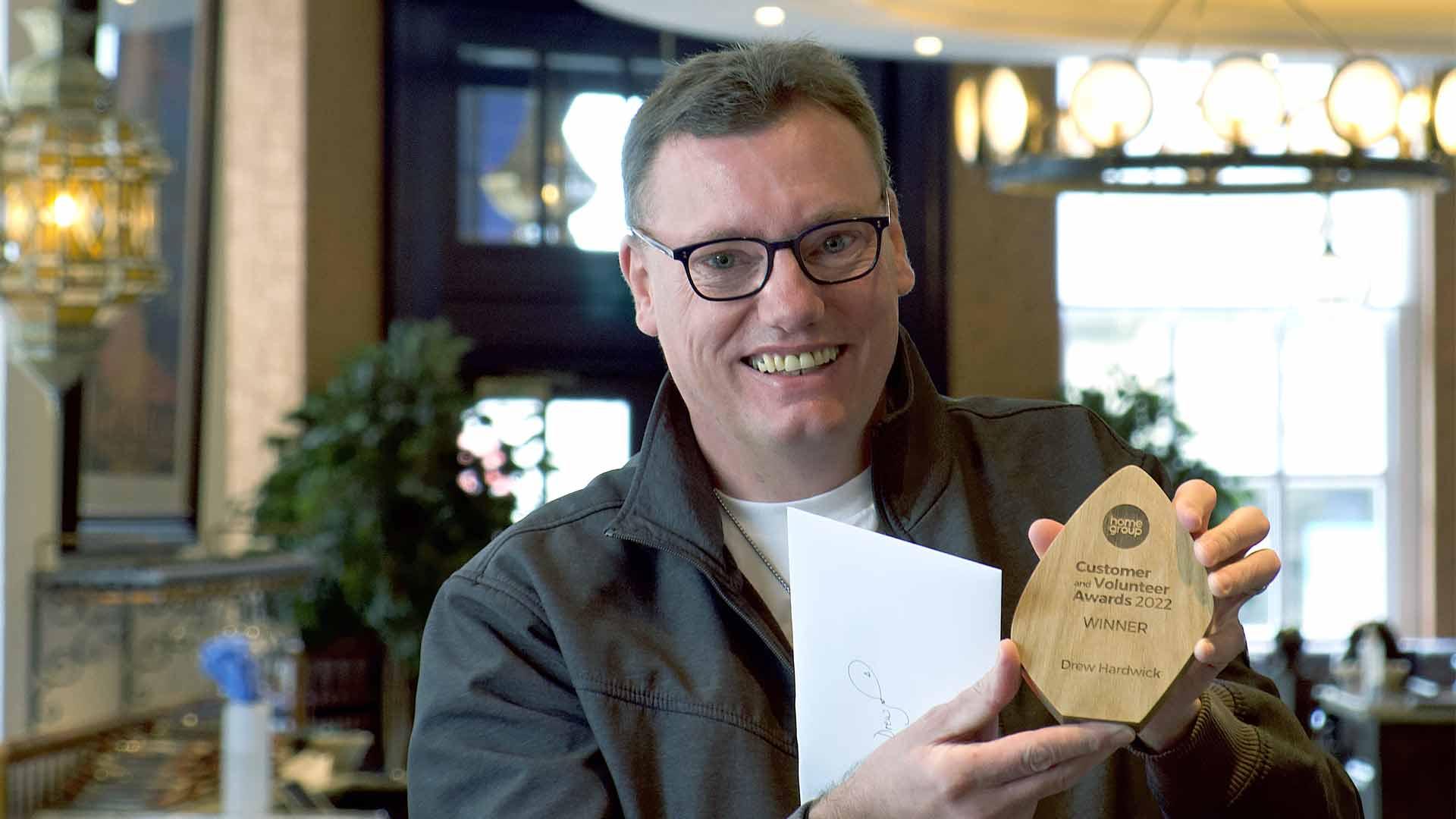 Customer, Drew, holding his 2022 award